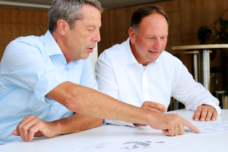 Zwei Kollegen arbeiten an Unterlagen